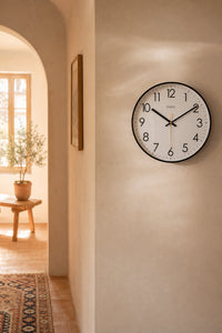 Horloge murale en albâtre de style classique, design élégant, fabriquée par Côté Horloge, avec un cadran visible et détails raffinés.